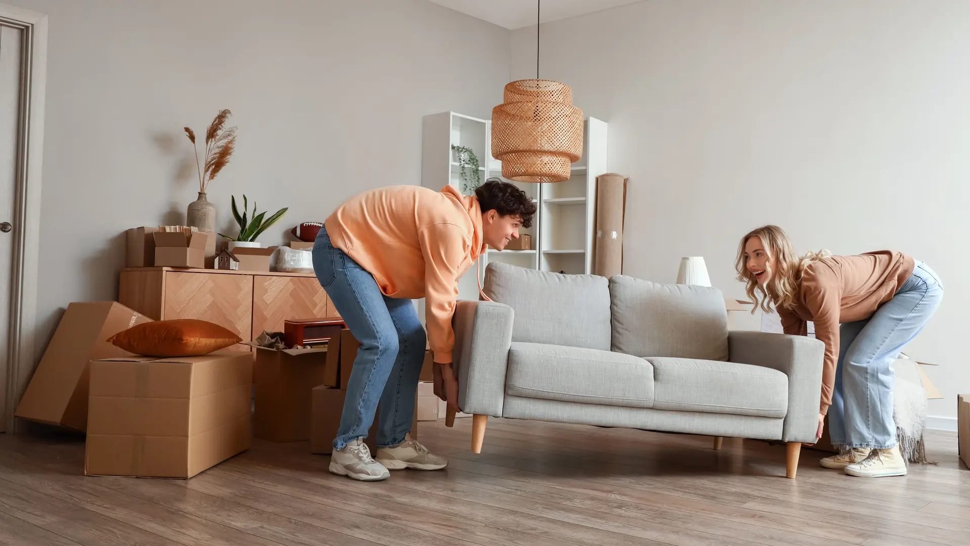 Paar trägt ein Sofa beim Einzug.
