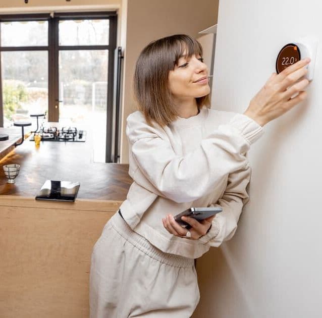Frau verstellt Heizungsregler im Haus
